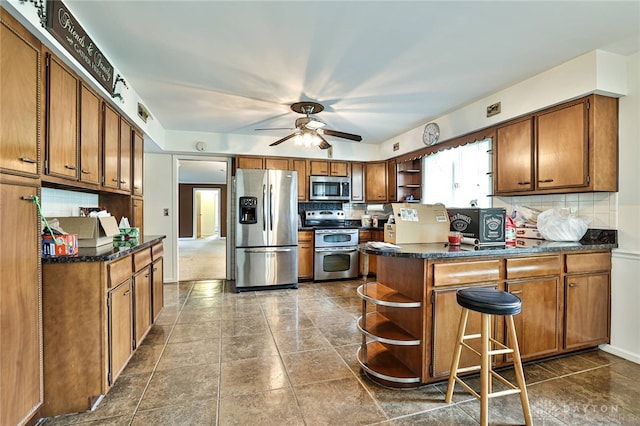 kitchen featuring open shelves, decorative backsplash, a peninsula, brown cabinets, and appliances with stainless steel finishes