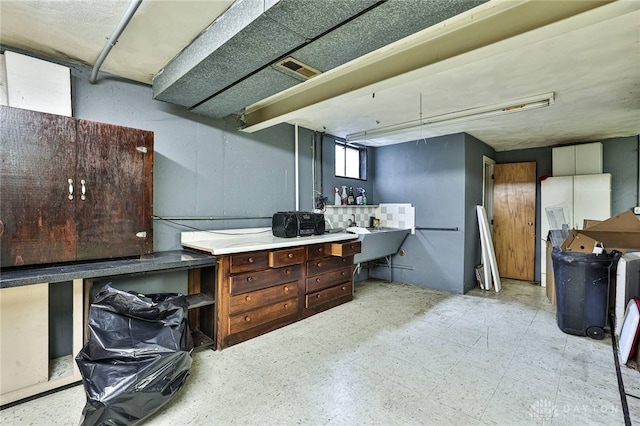 10699 Hamilton Ave, Cincinnati, OH 45231 - below grade area with a workshop area, tile patterned floors, and a sink