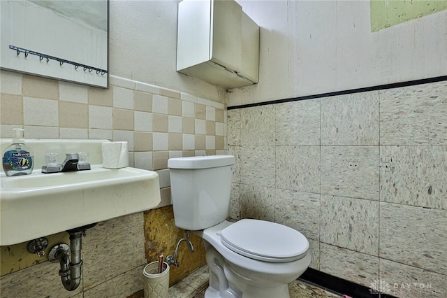10699 Hamilton Ave, Cincinnati, OH 45231 - bathroom featuring toilet, tile walls, and a sink