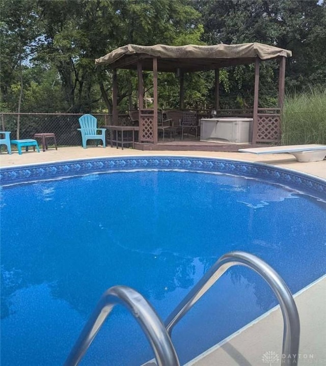 10699 Hamilton Ave, Cincinnati, OH 45231 - swimming pool featuring a diving board and view of scattered trees