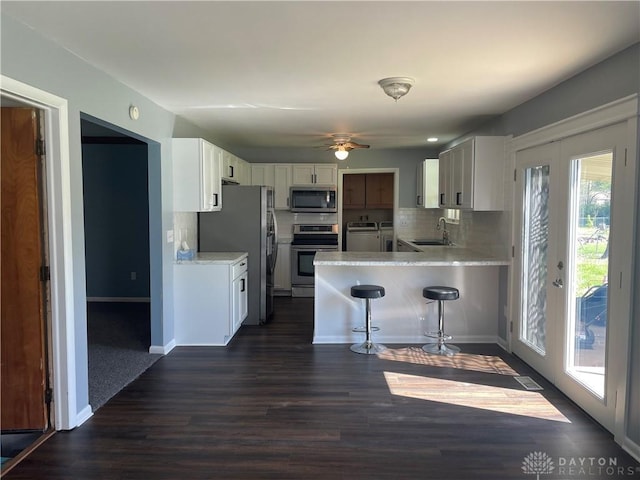 928 Shady Ln, Beavercreek, OH 45434 - kitchen with appliances with stainless steel finishes, a sink, a peninsula, separate washer and dryer, and light countertops
