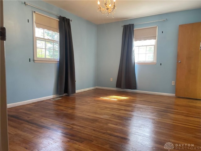 928 Shady Ln, Beavercreek, OH 45434 - unfurnished room featuring plenty of natural light, wood finished floors, a chandelier, and baseboards