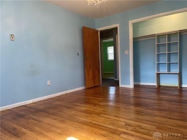 928 Shady Ln, Beavercreek, OH 45434 - unfurnished bedroom featuring wood finished floors, a chandelier, baseboards, and a closet