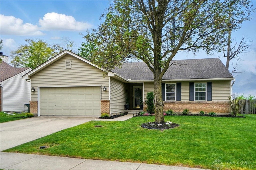 single story home featuring driveway, roof with shingles, a front yard, an attached garage, and brick siding