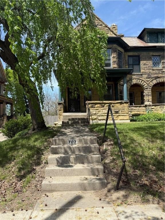 view of front of house with covered porch and stone siding