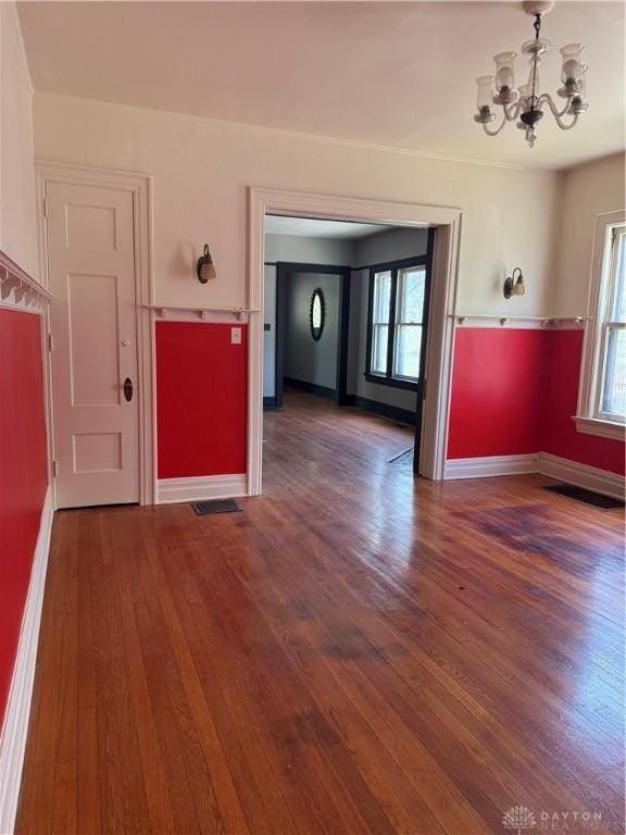 interior space featuring a chandelier, baseboards, and wood finished floors