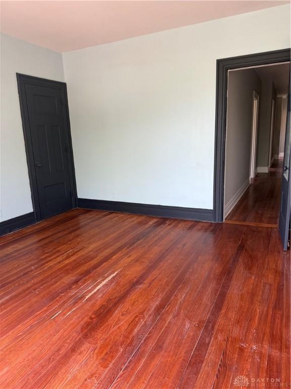 unfurnished room featuring wood finished floors and baseboards