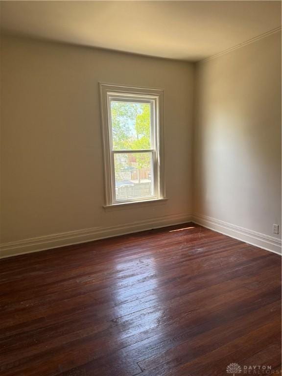 unfurnished room with dark wood finished floors and baseboards