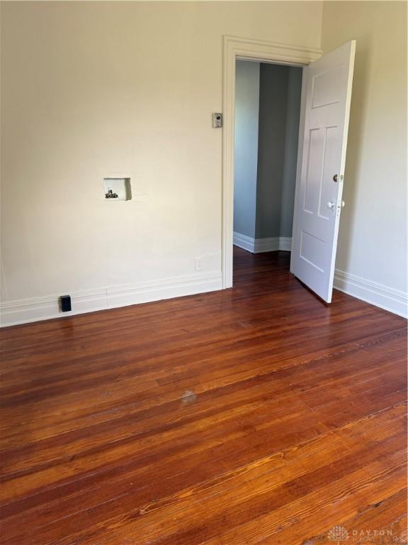 spare room featuring wood finished floors and baseboards