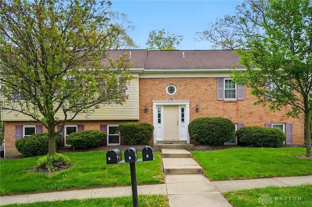 bi-level home featuring brick siding and a front yard