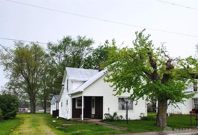 view of front of property featuring a chimney and a front yard