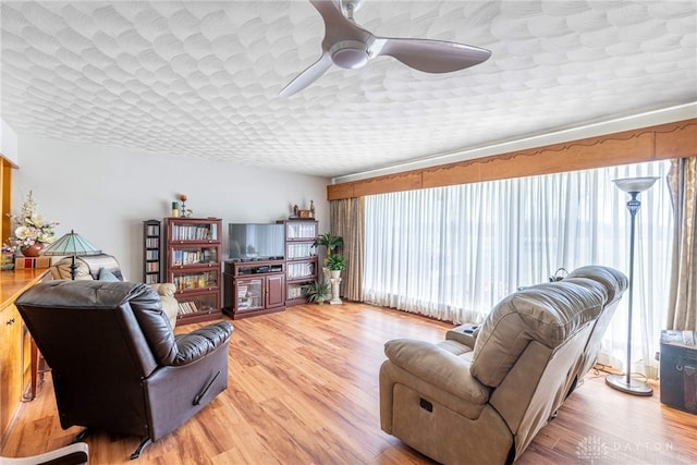living area featuring a ceiling fan and light wood finished floors