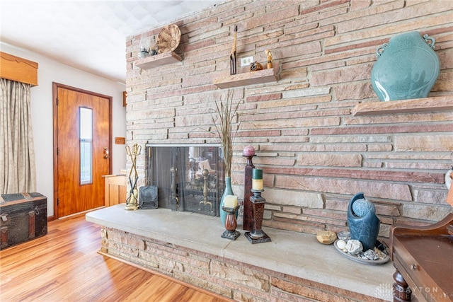living room featuring baseboards, wood finished floors, and a fireplace