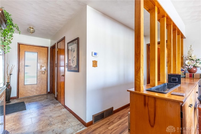 hall featuring baseboards and visible vents