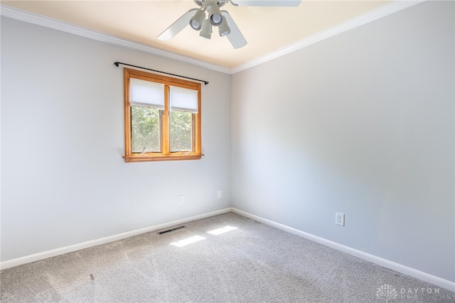 carpeted empty room with a ceiling fan, baseboards, visible vents, and ornamental molding