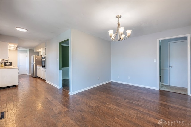 interior space with an inviting chandelier, baseboards, dark wood-style floors, and visible vents