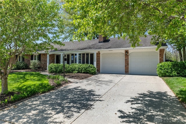 ranch-style house with a front lawn, a chimney, brick siding, concrete driveway, and an attached garage