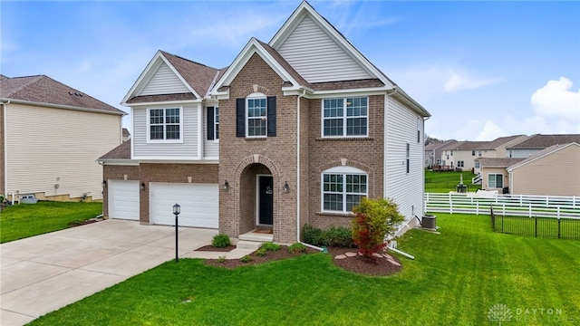1621 Stonebury Ct, Xenia, OH 45385 - view of front of home with brick siding, a garage, concrete driveway, and central air condition unit