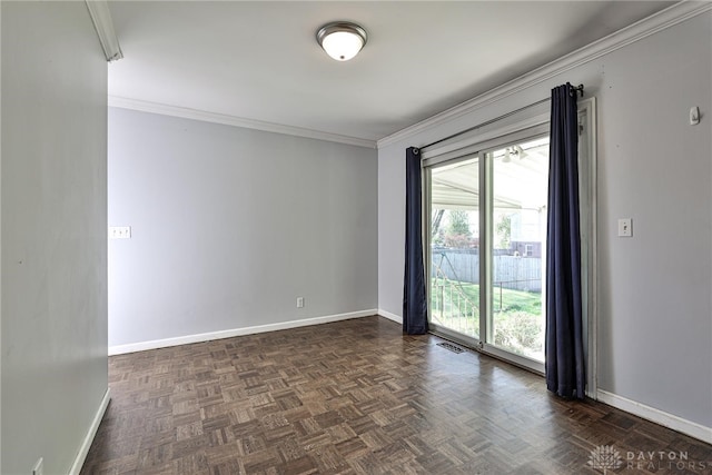 empty room featuring baseboards, ornamental molding, and visible vents