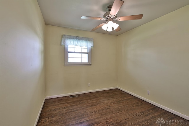 empty room with baseboards, dark wood-style flooring, ceiling fan, and visible vents