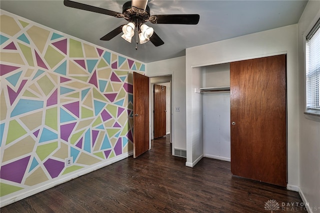 unfurnished bedroom featuring baseboards, visible vents, wood finished floors, and a closet