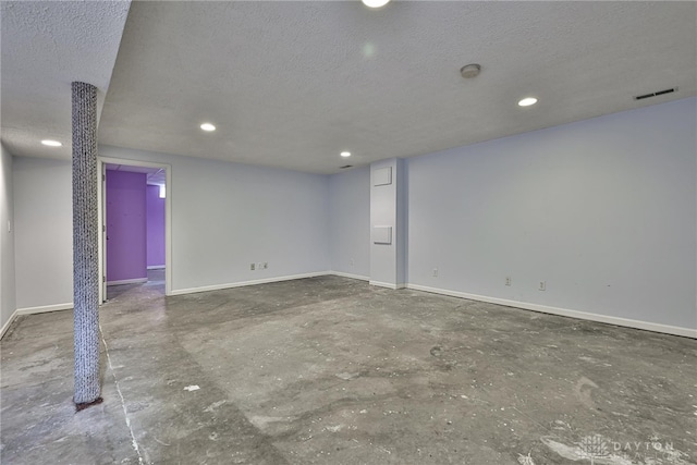 finished basement with baseboards, recessed lighting, a textured ceiling, and visible vents