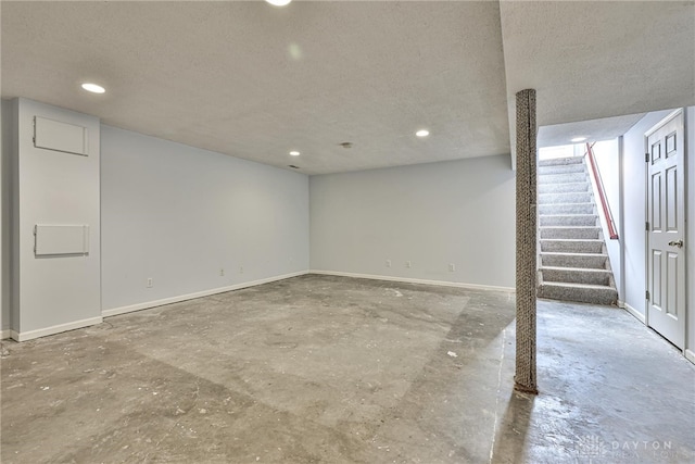 finished basement with baseboards, recessed lighting, and a textured ceiling