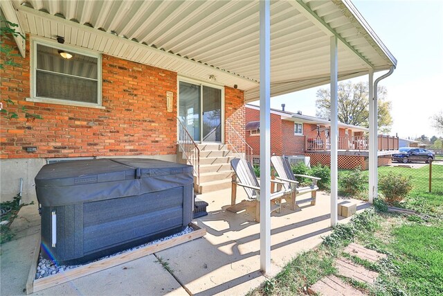 view of patio / terrace featuring a hot tub and entry steps