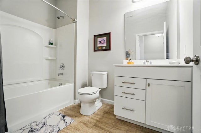 full bath featuring washtub / shower combination, vanity, toilet, baseboards, and wood finished floors