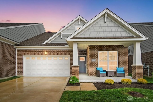 craftsman inspired home with concrete driveway, brick siding, an attached garage, and roof with shingles