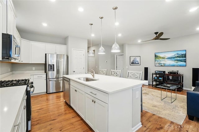 kitchen with a sink, stainless steel appliances, a ceiling fan, open floor plan, and recessed lighting