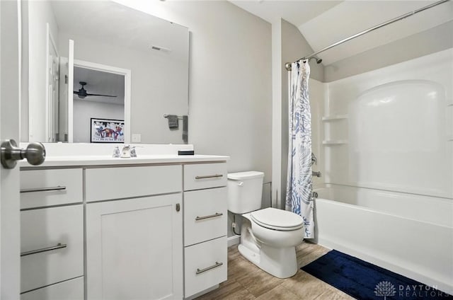 full bathroom with visible vents, vanity, wood finished floors, toilet, and shower / tub combo