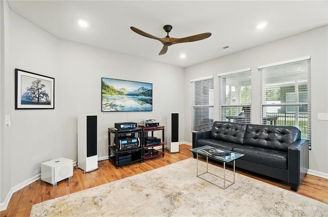 living area with baseboards, ceiling fan, visible vents, and wood finished floors