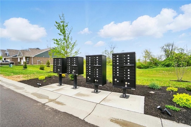 view of home's community with mail area and a yard