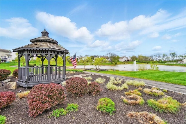 surrounding community with a gazebo, a water view, and a lawn