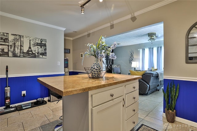 509 Hamilton Ave, New Carlisle, OH 45344 - kitchen with white cabinetry, wainscoting, track lighting, light tile patterned flooring, and a kitchen island
