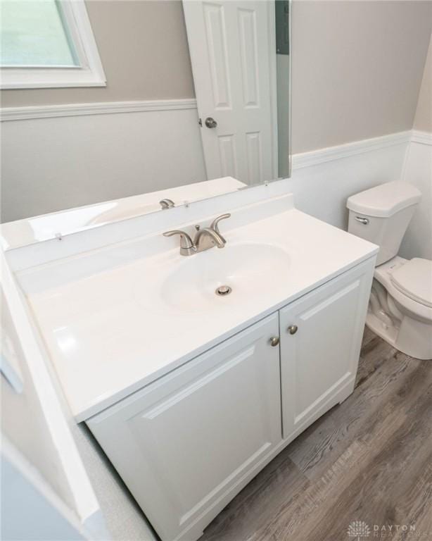 bathroom featuring vanity, toilet, and wood finished floors