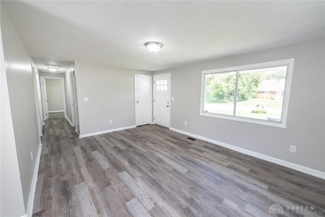 interior space featuring baseboards, wood finished floors, and visible vents