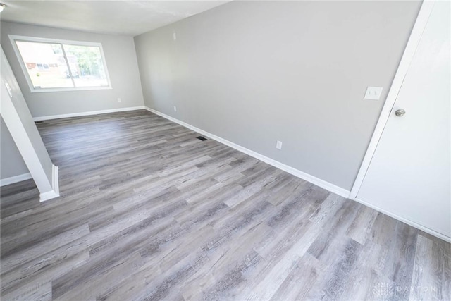 unfurnished room with baseboards and wood finished floors