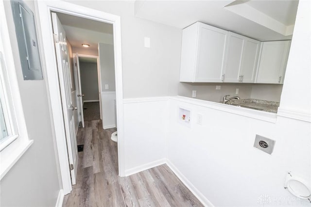 clothes washing area with cabinet space, washer hookup, light wood-style floors, electric dryer hookup, and electric panel