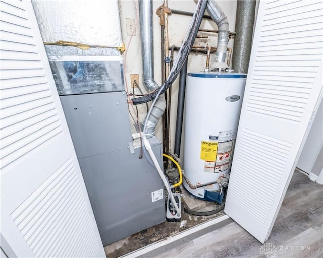 utility room featuring heating unit and water heater