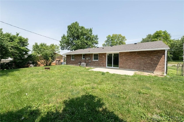 back of property with a lawn, a patio area, and brick siding