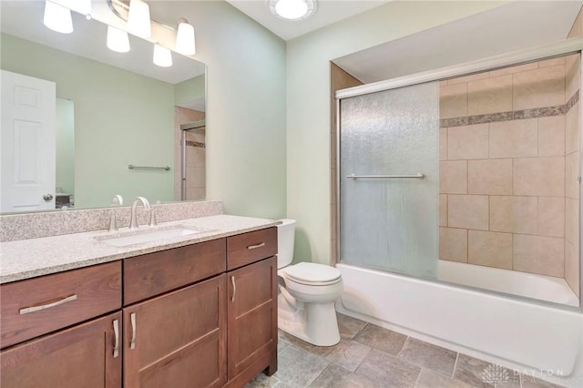 bathroom with vanity, enclosed tub / shower combo, and toilet