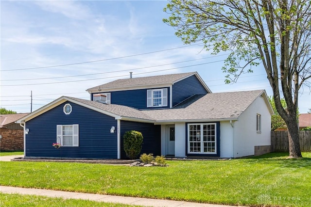traditional-style house featuring fence, a shingled roof, and a front yard