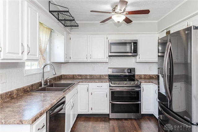 kitchen with white cabinets, ceiling fan, a sink, stainless steel appliances, and dark wood-type flooring