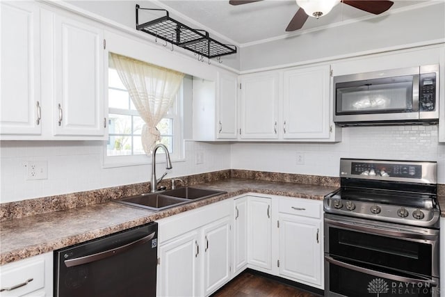 kitchen with stainless steel appliances, a ceiling fan, white cabinetry, and a sink