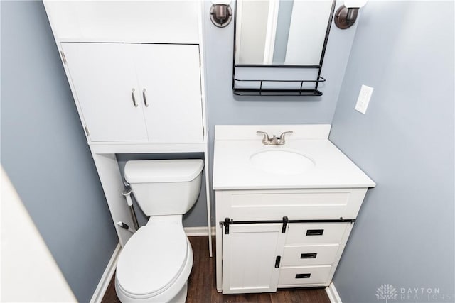 bathroom with vanity, baseboards, toilet, and wood finished floors