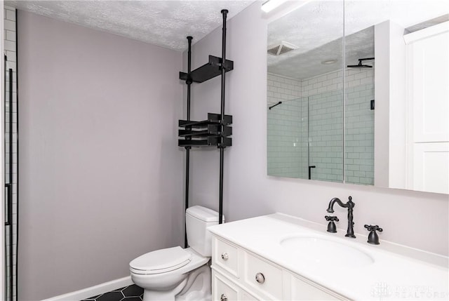 bathroom with a textured ceiling, tile patterned flooring, vanity, toilet, and tiled shower