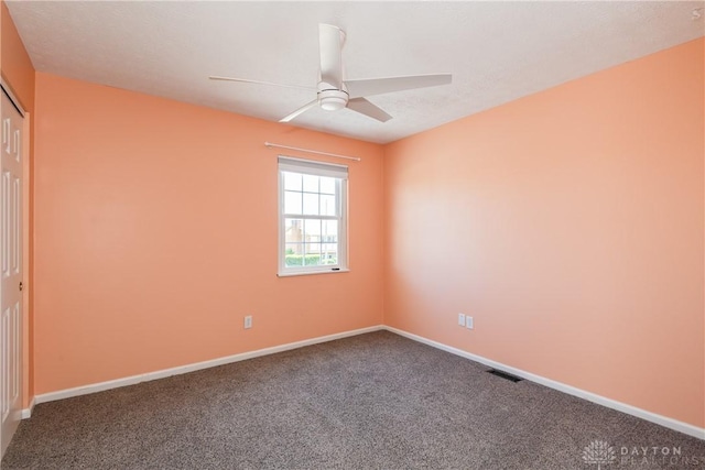 carpeted empty room with a ceiling fan, baseboards, and visible vents