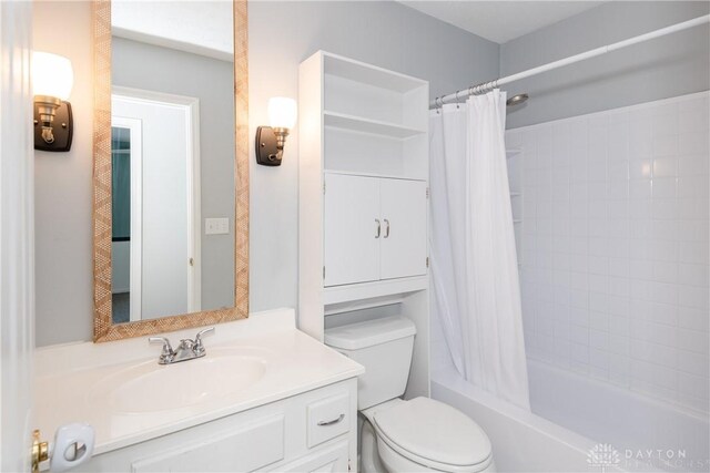 bathroom with toilet, shower / tub combo with curtain, and vanity